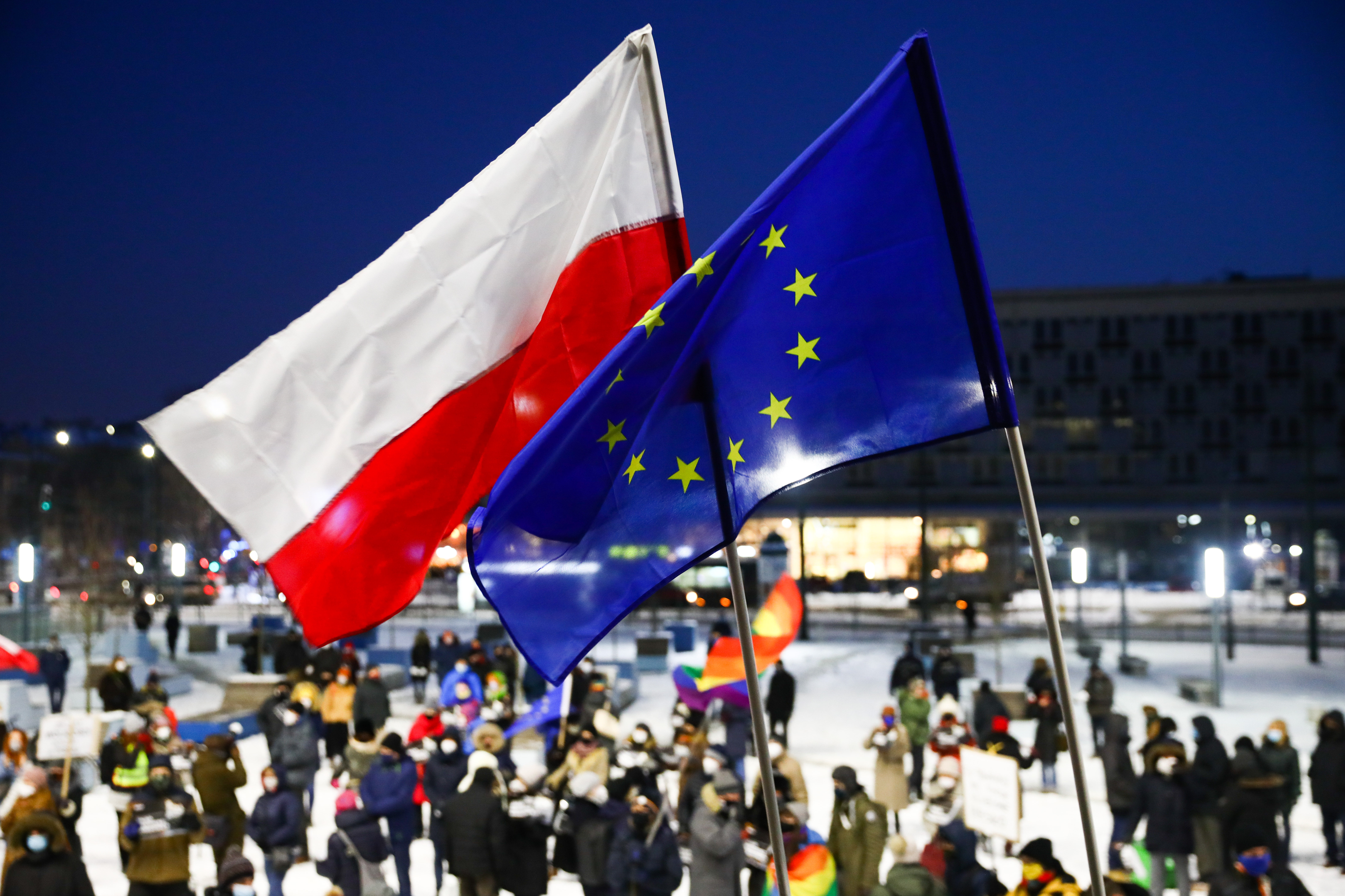 Demonstranten protestieren in Krakau mit der polnischen und der EU-Flagge gegen die geplante Mediensteuer