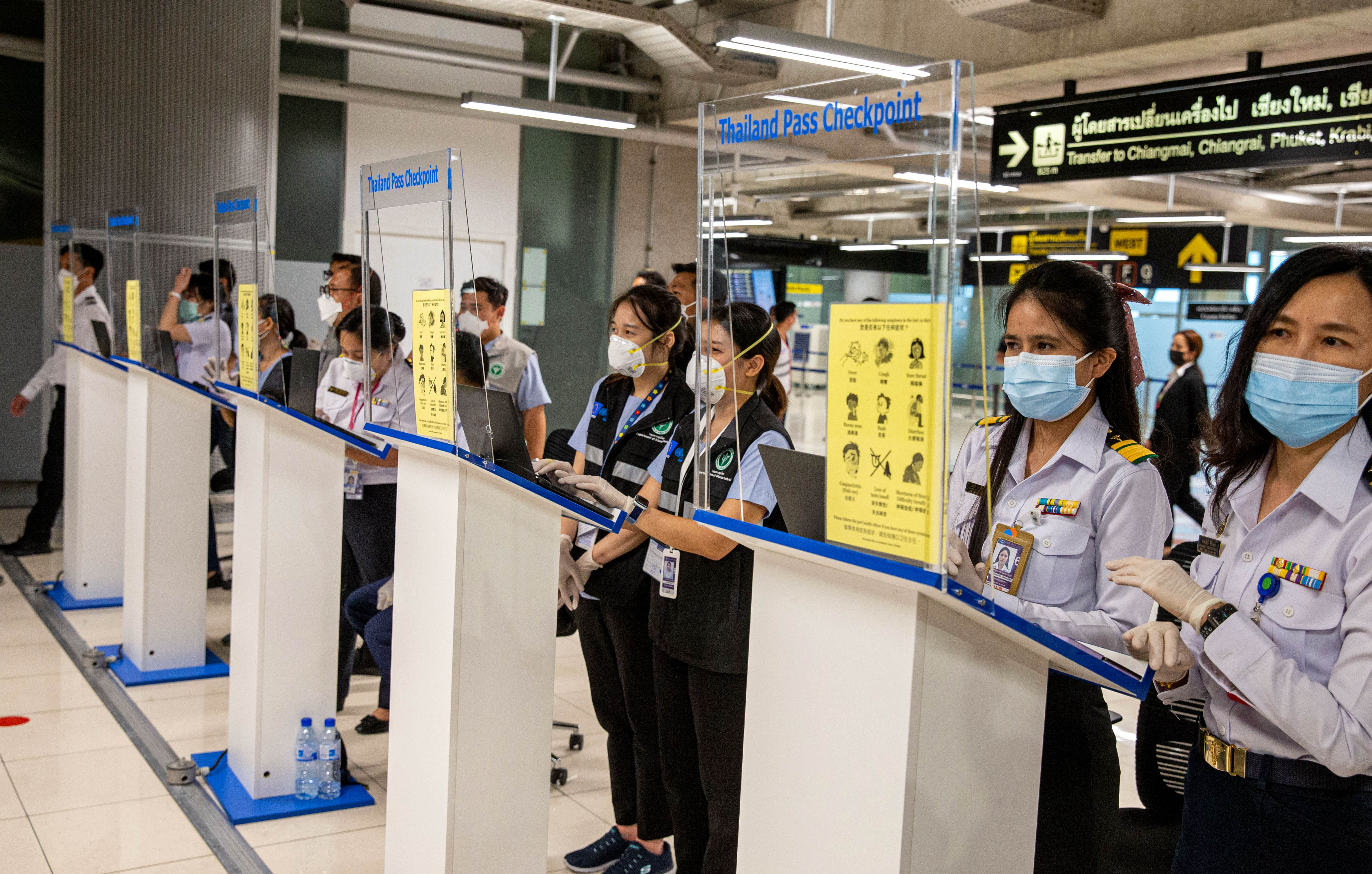 Mitarbeiterinnen warten auf Reisende am Suvarnabhumi International Airport in Bangkok