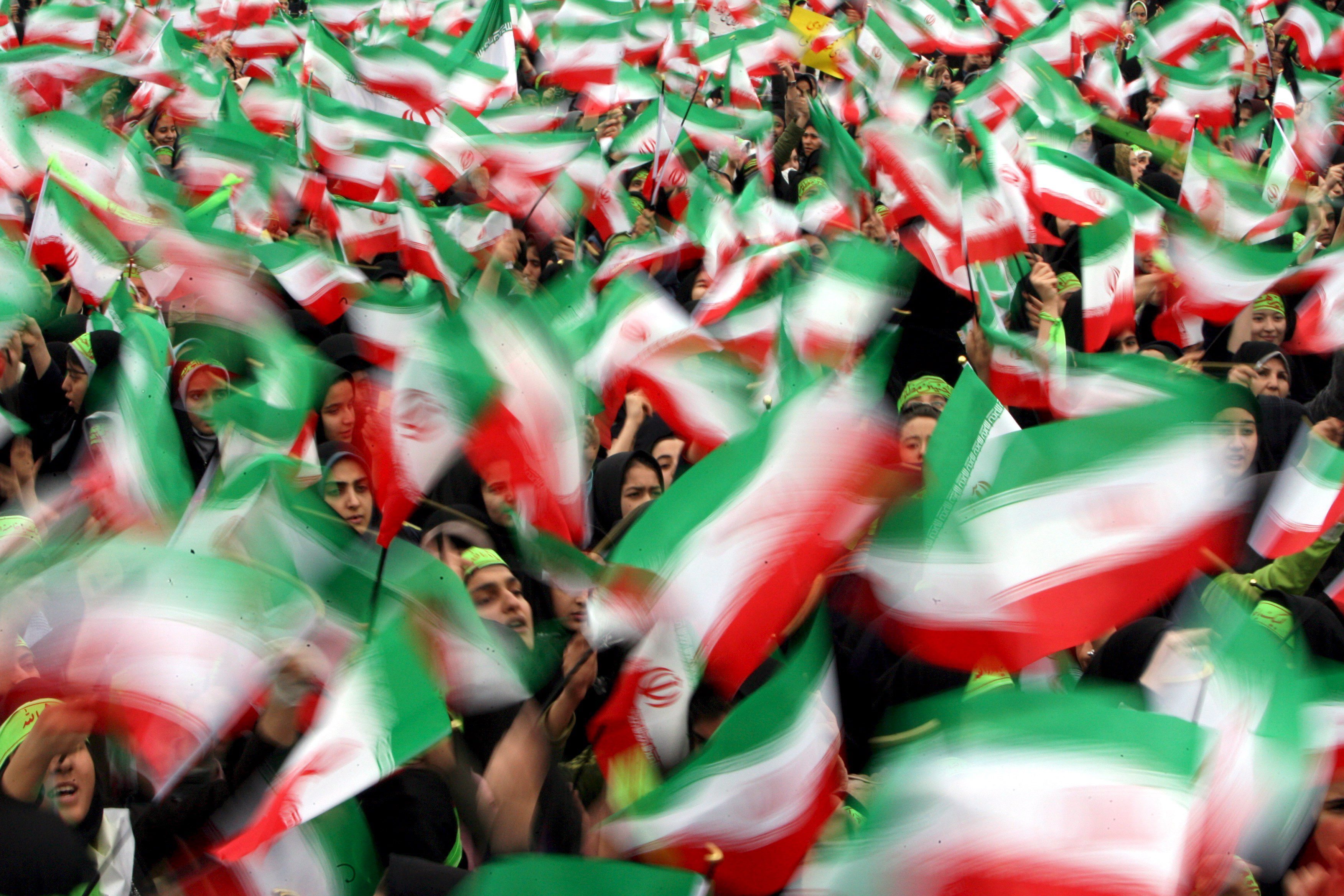 Iranian female students waving national flags during the 30th anniversary of the 1979