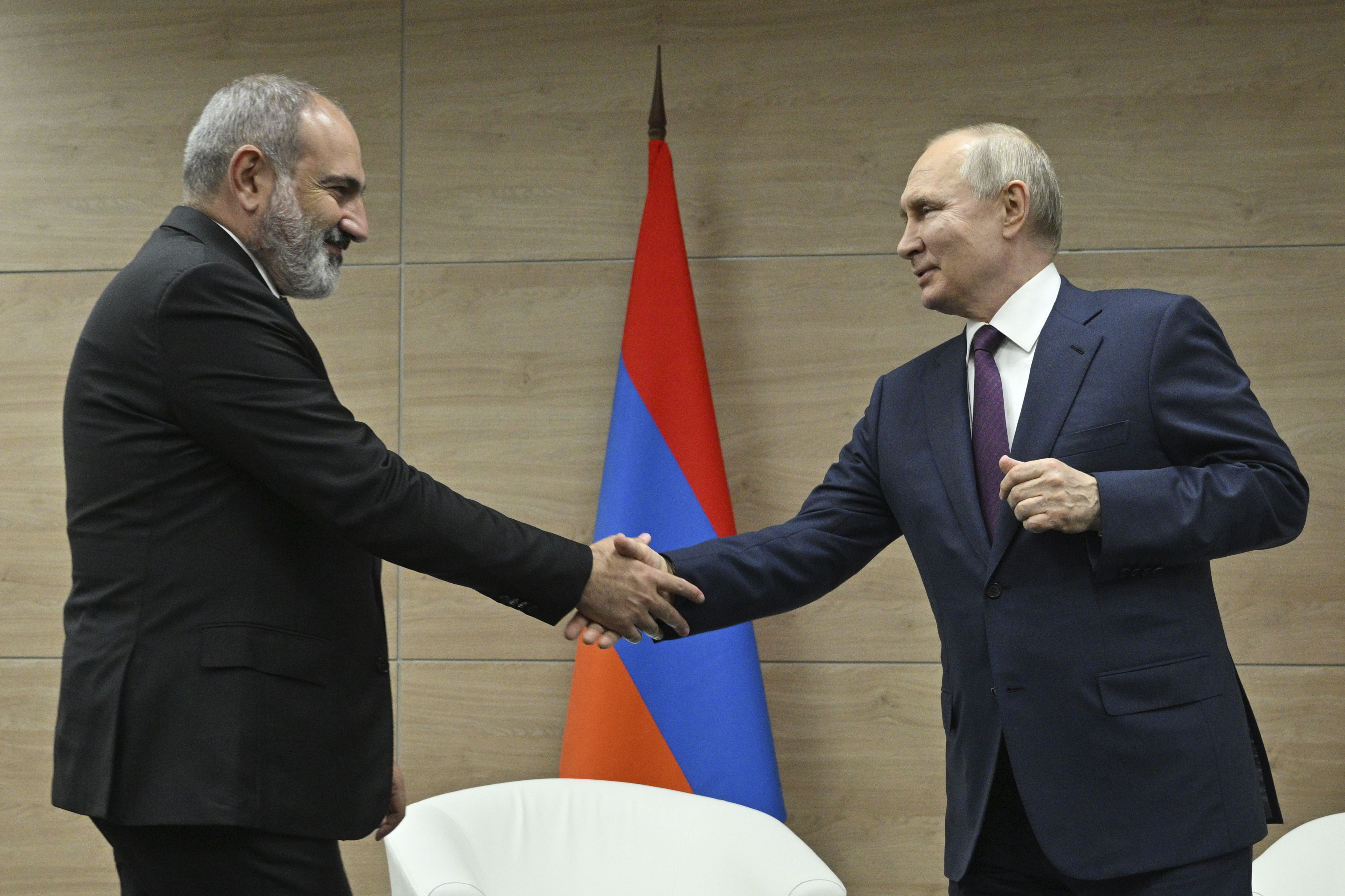 Russian President Vladimir Putin, right, and Armenian Prime Minister Nikol Pashinyan shakes hands during their meeting in the resort city of Sochi, Russia