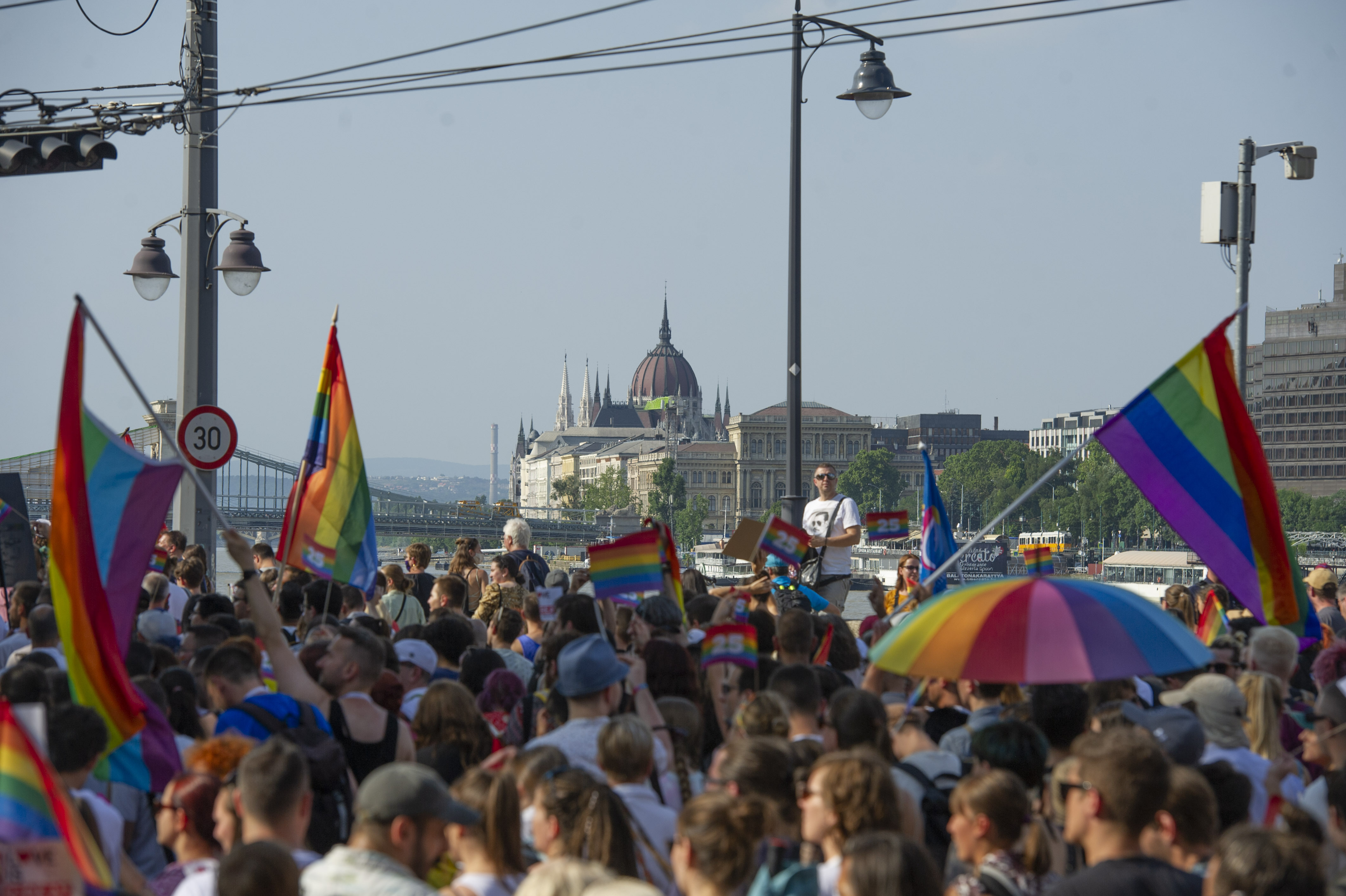 Das ungarische Parlamentsgebäude ist hinter Menschen abgebildet, die an der jährlichen Budapest Pride teilnehmen