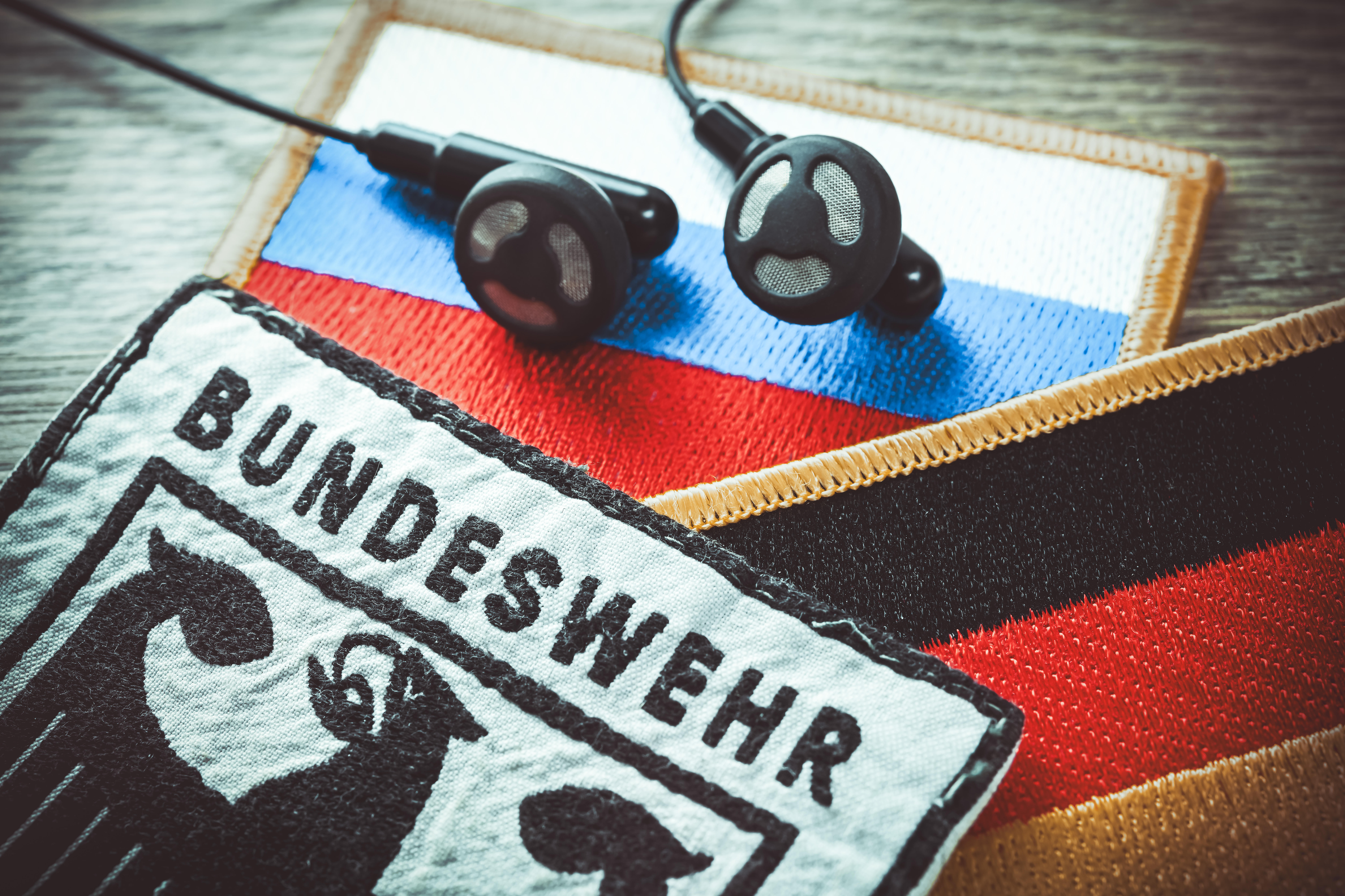 Bundeswehr-Aufnäher und Kopfhörer auf Russland-Fahne, Symbolfoto Taurus-Abhöraffäre 