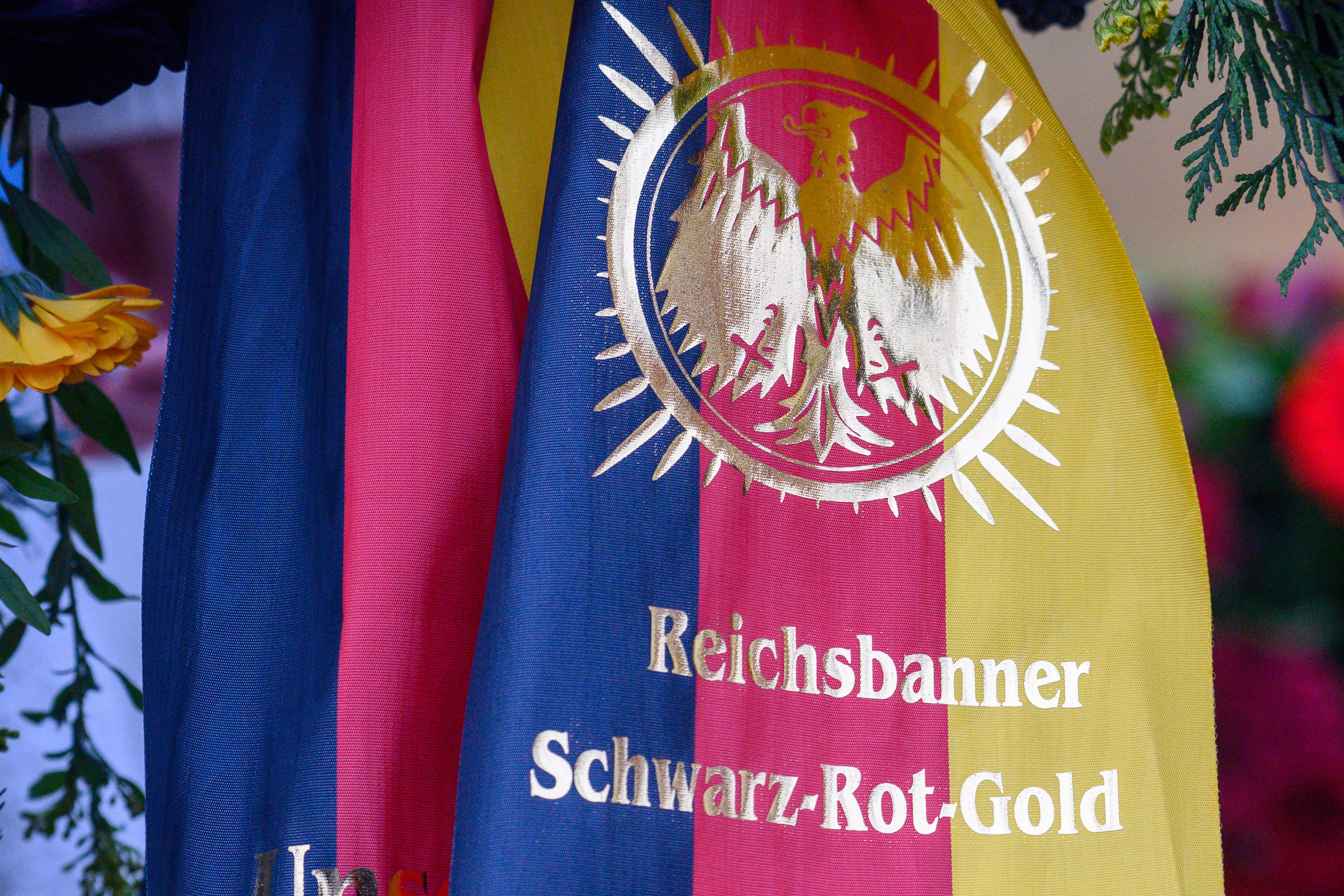 "Reichsbanner Schwarz-Rot-Gold" steht auf einer Schleife an einem Kranz. 