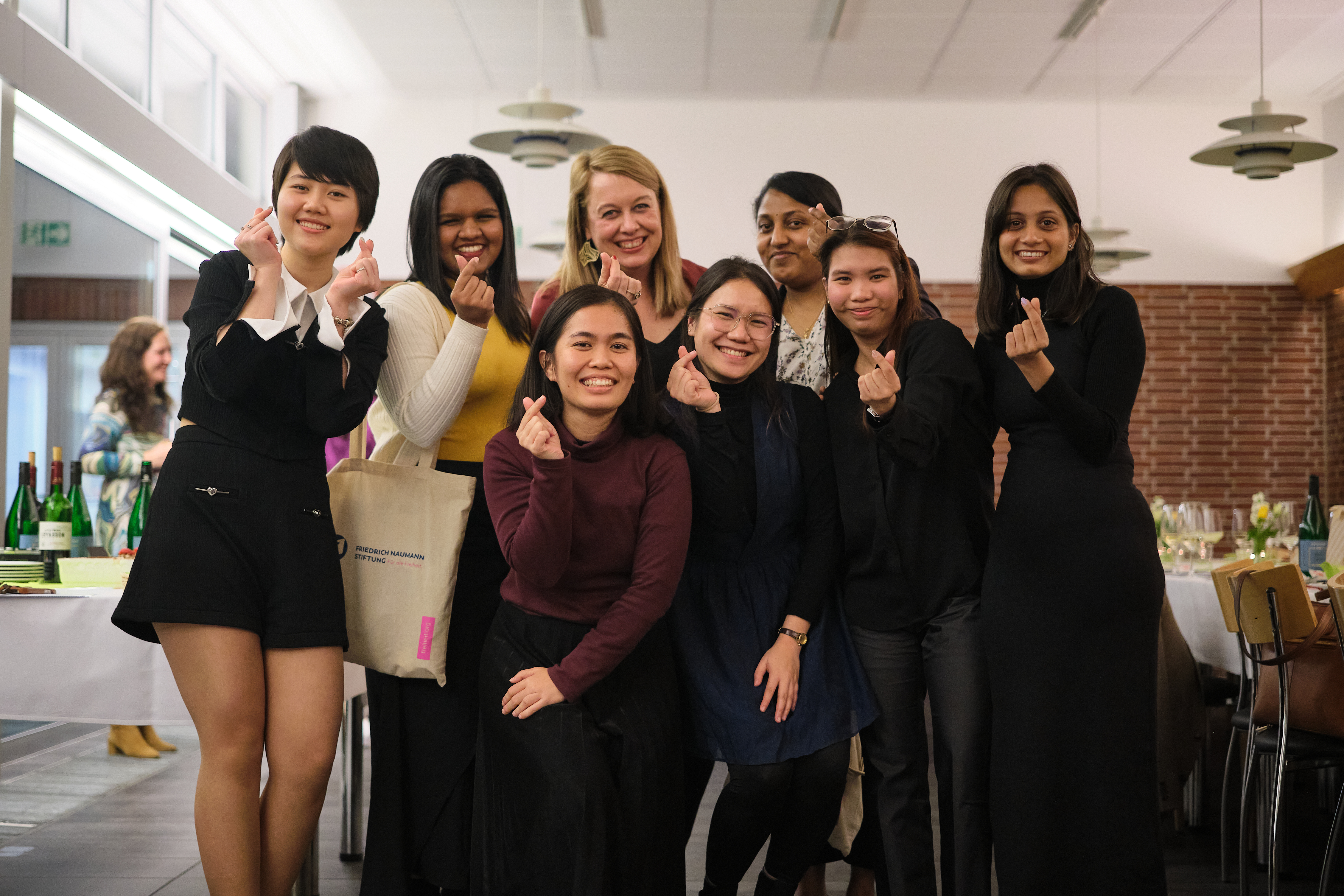 Kasturi (third person standing from the right) with friends she met in Gummersbach. All of them show poses of Korean finger hearts.