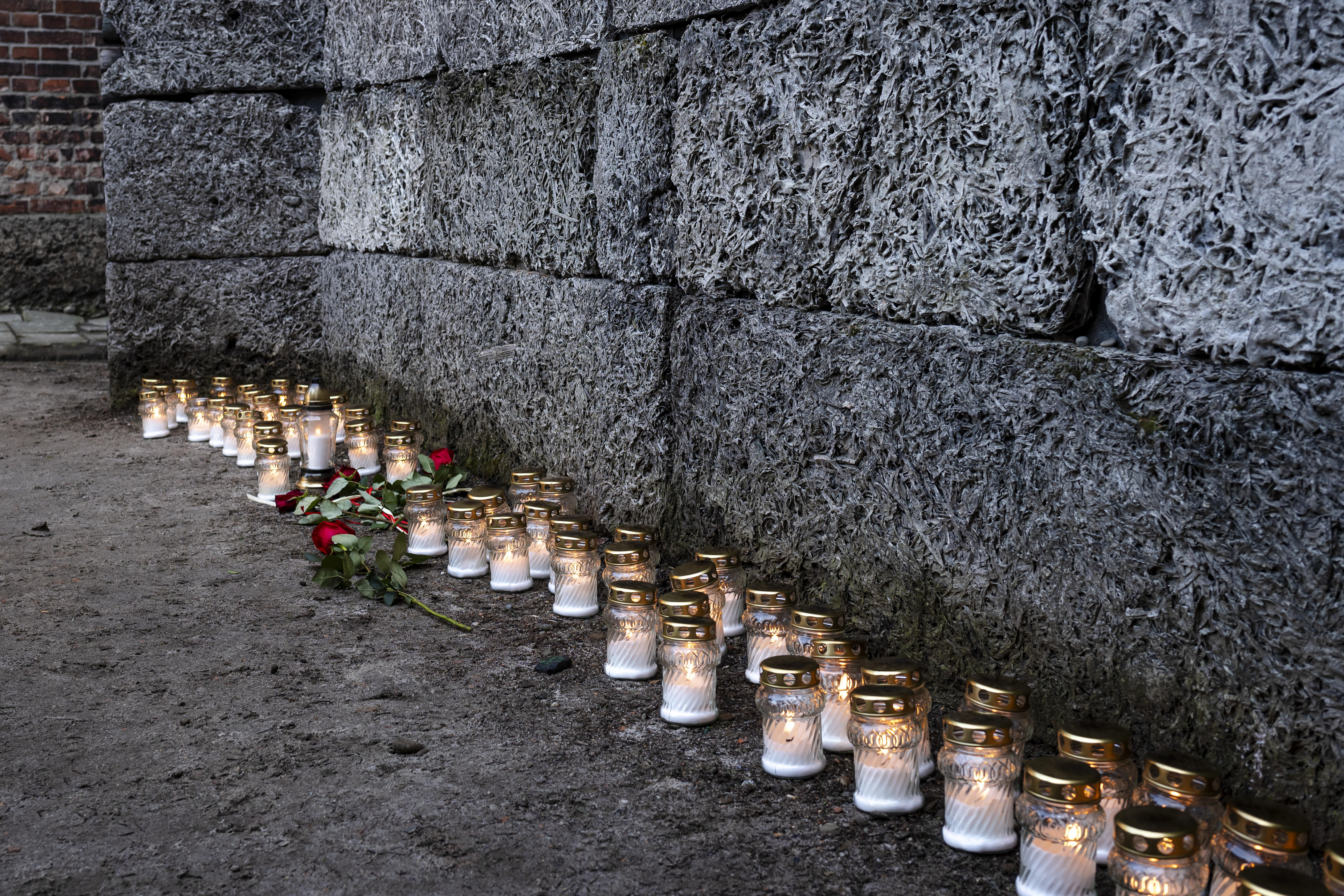 Kerzen und Kränze von Überlebenden des Konzentrationslagers Auschwitz stehen an der sogenannten „Todesmauer“ auf dem Gelände des ehemaligen Konzentrationslagers Auschwitz I anlässlich des 80. Jahrestages der Befreiung des Lagers am 27. Januar 2025 in Oswiecim, Polen. T