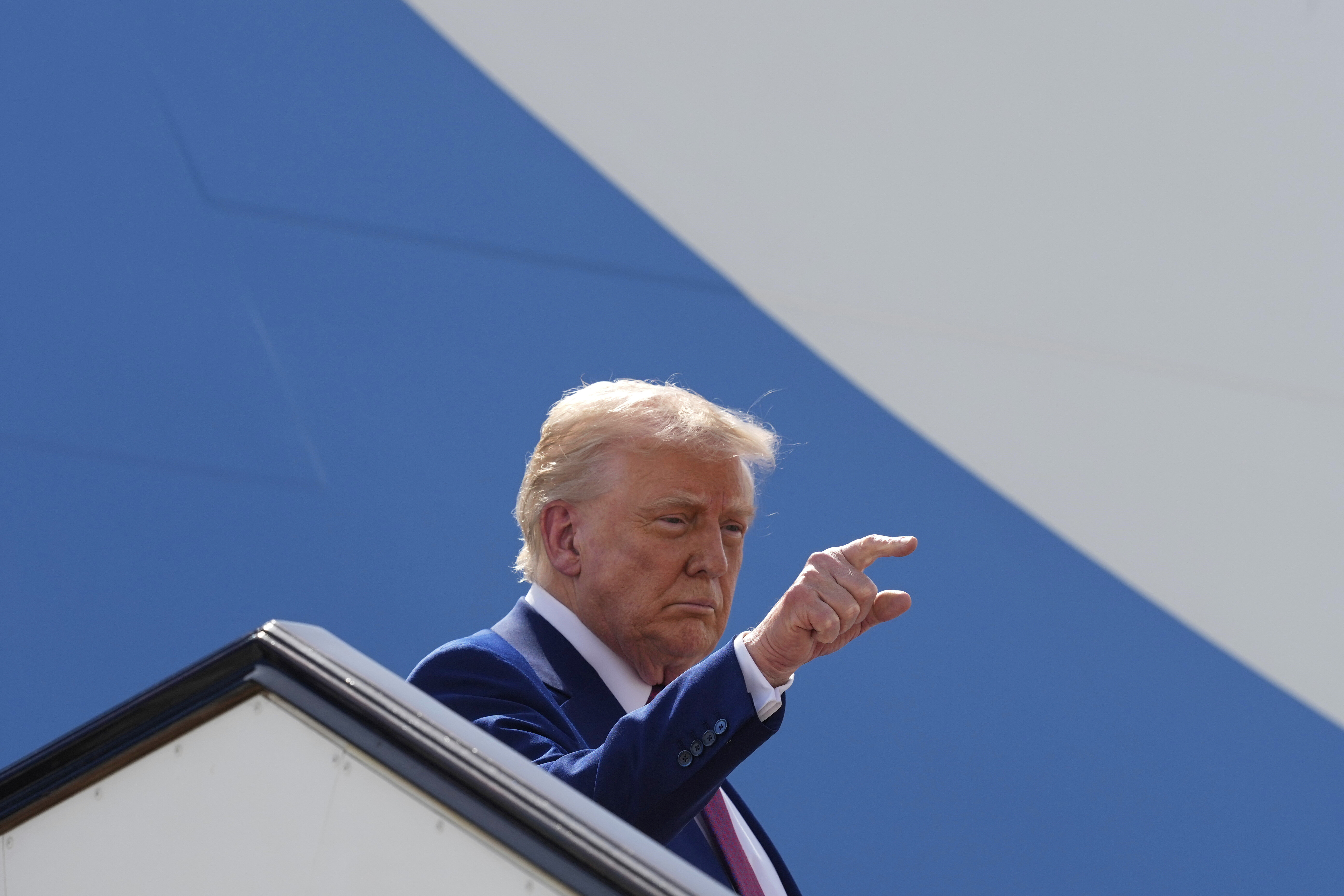 Präsident Donald Trump gestikuliert, während er an Bord der Air Force One geht, um den Luftwaffenstützpunkt Al Udeid zu verlassen, Donnerstag, 15. Mai 2025, in Doha, Katar.
