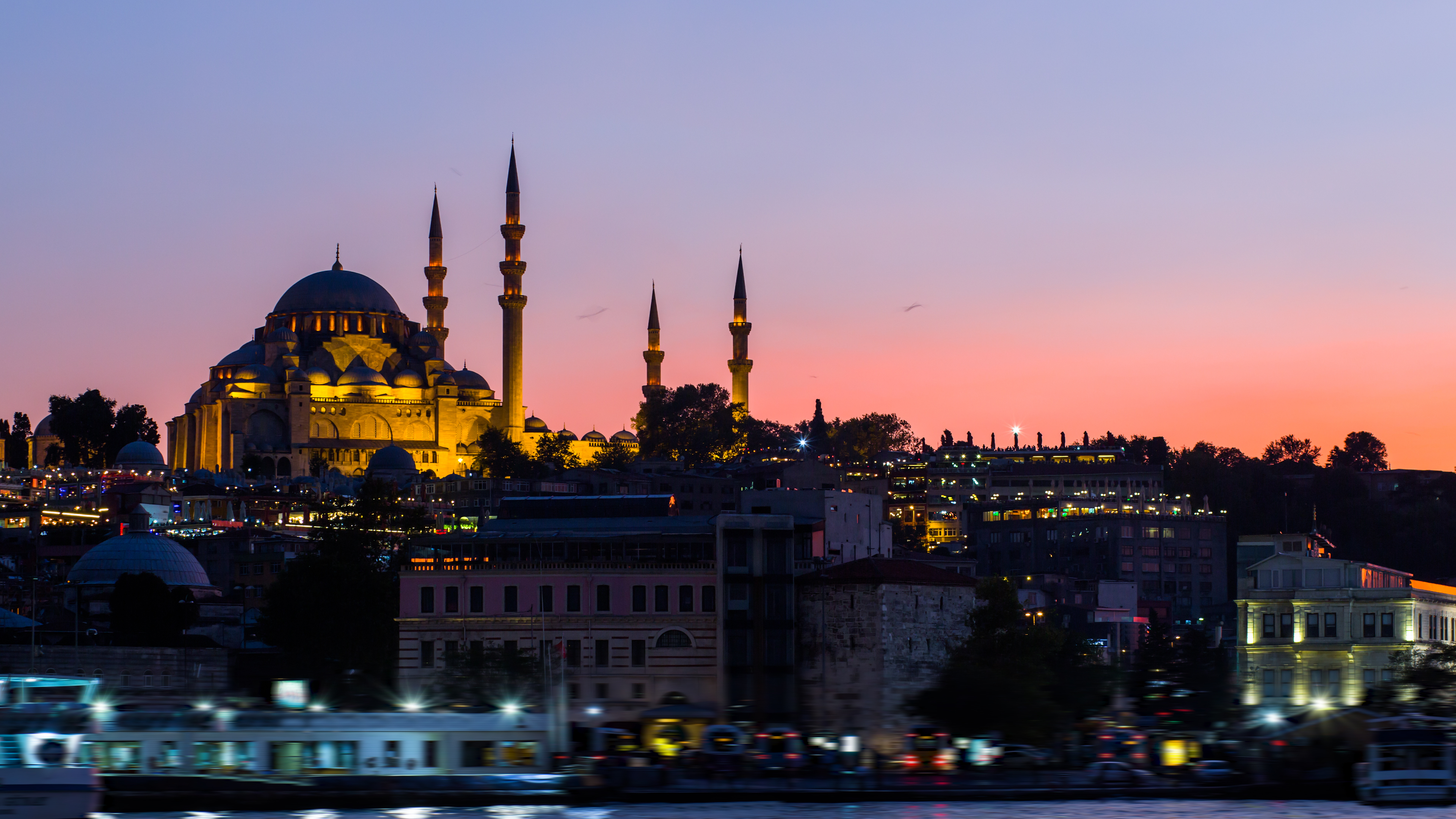 Istanbul Cityscape With Suleymaniye Mosque With Tourist Ships Floating At Bosphorus At Night