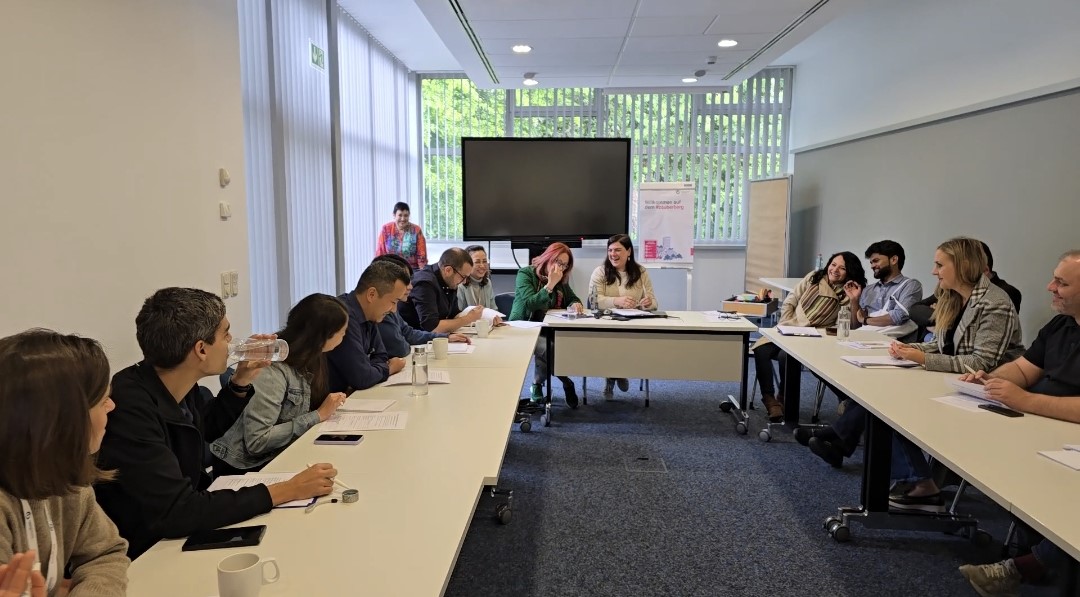 Three groups role-playing in negotiation and coalition-building: green youth group (left), NGO (middle) and liberal party (right)