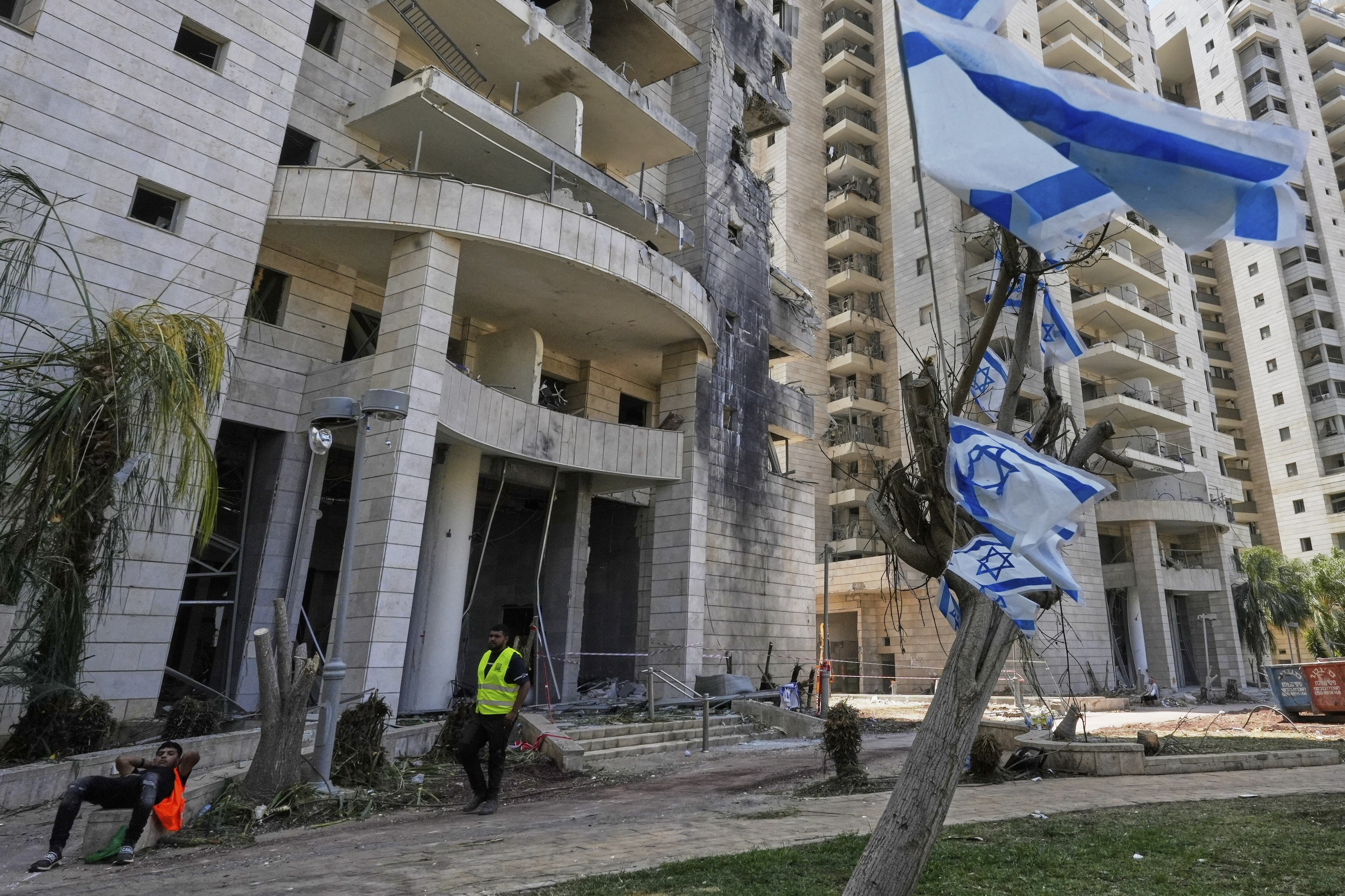 Ein israelischer Sicherheitsbeamter steht am Eingang eines Wohngebäudes, das von einer aus dem Iran abgefeuerten Rakete getroffen wurde
