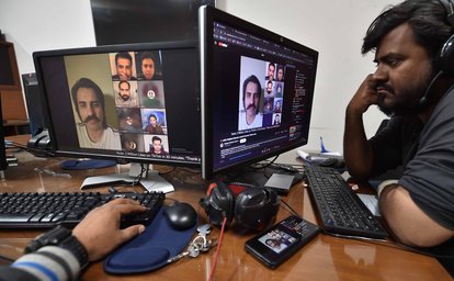 Menschen beobachten eine virtuelle Wahlkampfkundgebung der Partei Pakistan Tehreek-e-Insaf (PTI) des inhaftierten ehemaligen Premierministers Imran Khan in einem Raum in Karatschi, Pakistan