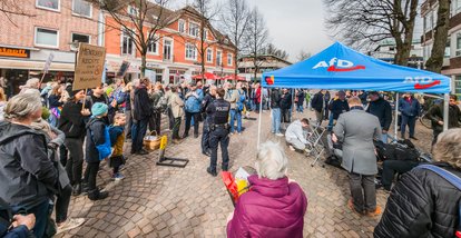Mitglieder der AfD bauen ihren Informationsstand zur Europawahl ab, nachdem dieser ständig von singenden und skandierenden Bürgern und Demonstranten umringt war.