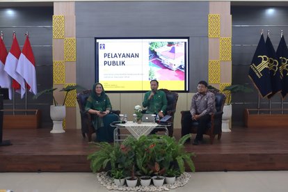 Narasumber dan moderator Kanwil dan Kemenkumham duduk di depan layar yang menampilkan banner kegiatan.