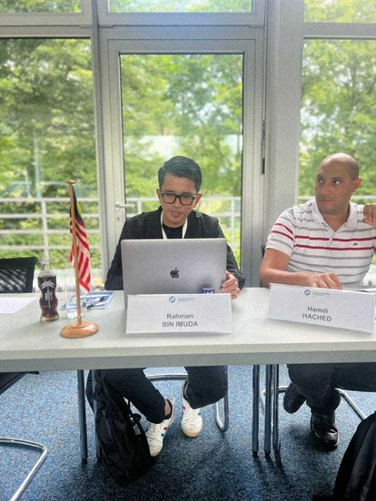 Rahman Imuda sitting in one of IAF sessions. Next to him sits another participant.