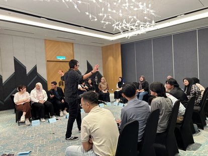 Rahman Imuda (standing) leading an ice-breaking session of a Werewolf game.