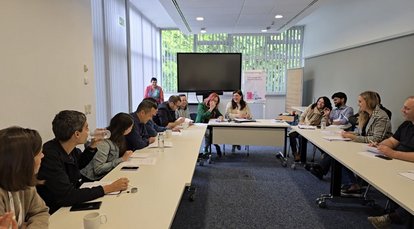 Three groups role-playing in negotiation and coalition-building: green youth group (left), NGO (middle) and liberal party (right)