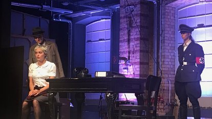 Robert Mohr (Lena Riedel) beim Verhör von Sophie Scholl. Im Hintergrund ein SS- Mann (Tabea Tafel)