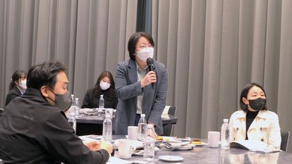 a woman from the audience is raising a question, standing