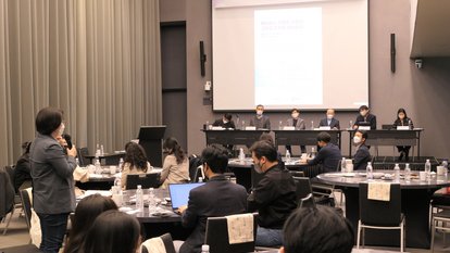 a woman from the audience is raising a question, standing