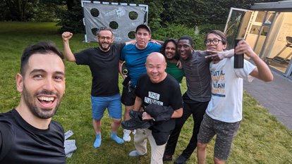 Philip Golingai with the other participants during leisure time. They were posing casually in front of a goal. 