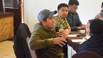 Salah satu peserta kegiatan tengah memegang mic dan berbicara.