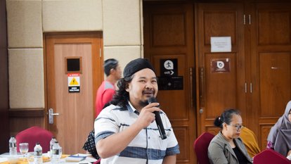 Seorang peserta kegiatan tampak berpartisipasi dalam sesi tanya jawab.