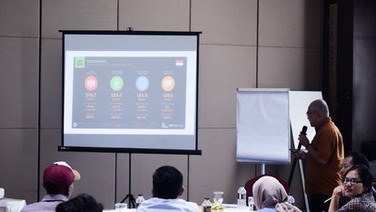 Narasumber Yan Kurniawan, Senior Analyst Drone Emprit, tengah menunjukkan video diskusi panel yang membahas tentang penggunaan Drone Emprit dalam analisis Pemilihan Presiden Republik Indonesia tahun 2024. Yan menjadi salah satu panelis dalam diskusi tersebut. Wajahnya tampak pada layar proyektor yang ditampilkan kepada para peserta.