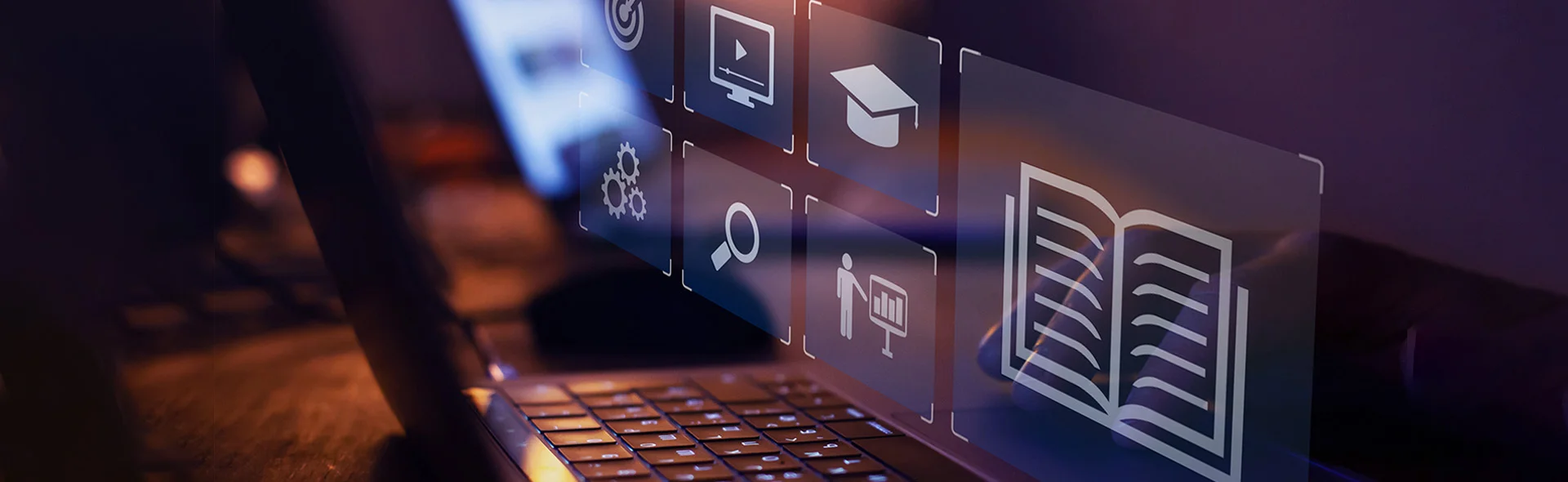 Symbolbild für digitale Bildungsangebote, man sieht die Tastatur eines Laptops mit verschiedenen Icons zum Thema Bildung