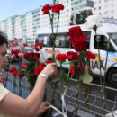 Menschen legen Blumen für eine bei den Protesten getötete Person nieder