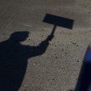 The shadow of a voter holding a campaign sign. Photographer: Callaghan O'Hare/Bloomberg