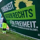 Zwei Mitarbeiter einer Firma für Werbeaufsteller bauen ein Wahlplakat der Partei „Bündnis 90/Die Grünen“ nach der Europawahl ab