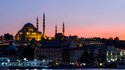 Istanbul Cityscape With Suleymaniye Mosque With Tourist Ships Floating At Bosphorus At Night