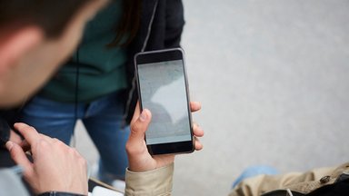 Ein Frau hält ein Smartphone in der Hand.