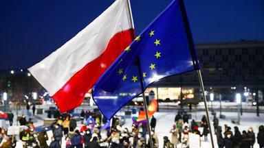 Demonstranten protestieren in Krakau mit der polnischen und der EU-Flagge gegen die geplante Mediensteuer