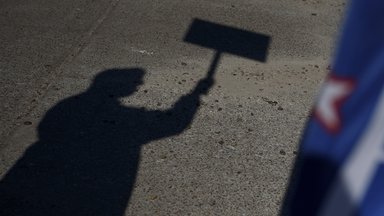 The shadow of a voter holding a campaign sign. Photographer: Callaghan O'Hare/Bloomberg