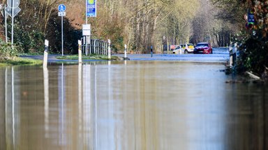 Zwei Autos stehen auf einer von dem über die Ufer getretenen Fluss Leine überfluteten Straße zwischen Hannover und Hemmingen in der Region Hannover. 
