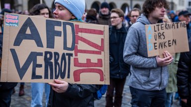 Eine Teilnehmerin einer Demonstration gegen Rechtsextremismus unter dem Motto «Nie wieder ist jetzt - alle zusammen gegen den Faschismus» trägt auf dem Neuen Markt vor dem Rathaus ein Schild mit der Aufschrift «AFD-Verbot jetzt»