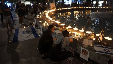 Menschen nehmen an einer Mahnwache bei Kerzenlicht teil