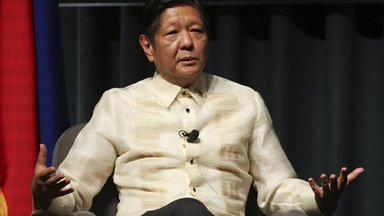 Auf dem Foto sitzt der philippinische Präsident Marcos Jr. in einer Diskussionshaltung.  