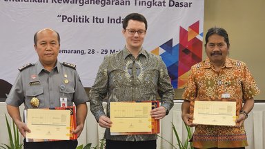 Hantor Situmorang (Head of Bureau of Public Relations, Law, and Cooperation at Ministry of Law and Human Rights Indonesia), standing alongside Dr. Stefan Diederich (Project Director at FNF Indonesia) and Agung Kristianto (Representative of the Head of the Office of National Unity and Politics of the Central Java Provincial Government). The three of them were holding the Annual Work Plan undertaken by each of their respective organizations.