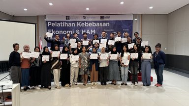 Participants of the event standing alongside Ganes Woro Retnani, Program Officer of FNF Indonesia, in front of a banner showing the event's details.