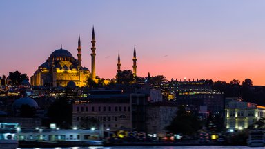 Istanbul Cityscape With Suleymaniye Mosque With Tourist Ships Floating At Bosphorus At Night