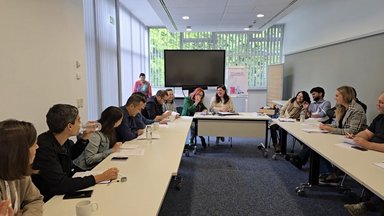Three groups role-playing in negotiation and coalition-building: green youth group (left), NGO (middle) and liberal party (right)