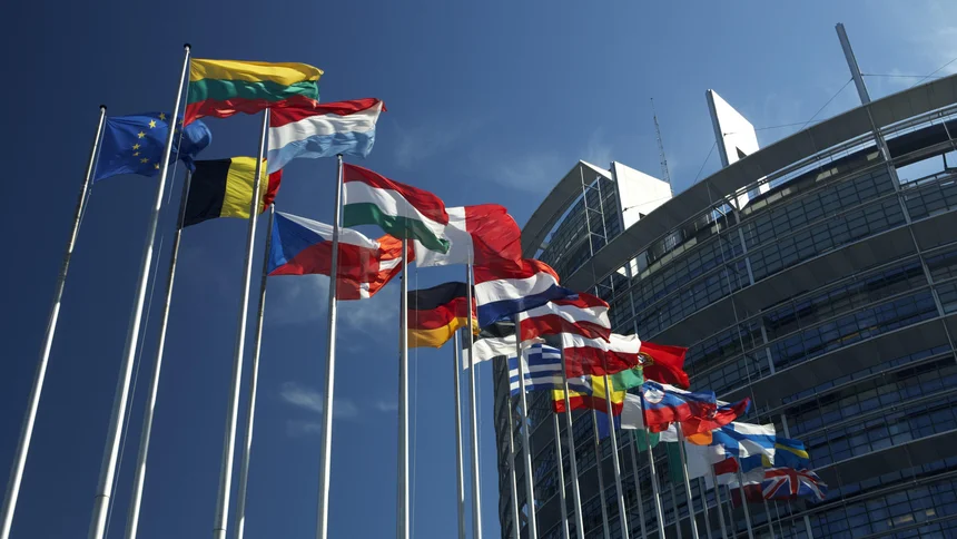 Fahnenmasten mit den Flaggen der EU-Staaten wehen vor dem Gebäude des Europaparlaments in Strasbourg, Frankreich, Europa