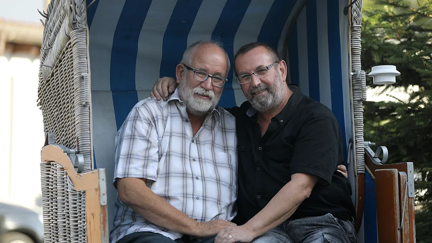 Das schwule Ehepaar, Bernd Göttling und Dieter Schmitz sitzt arm in arm in einem Strandkorb