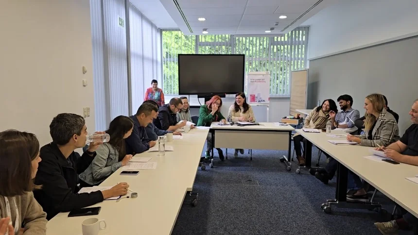 Three groups role-playing in negotiation and coalition-building: green youth group (left), NGO (middle) and liberal party (right)